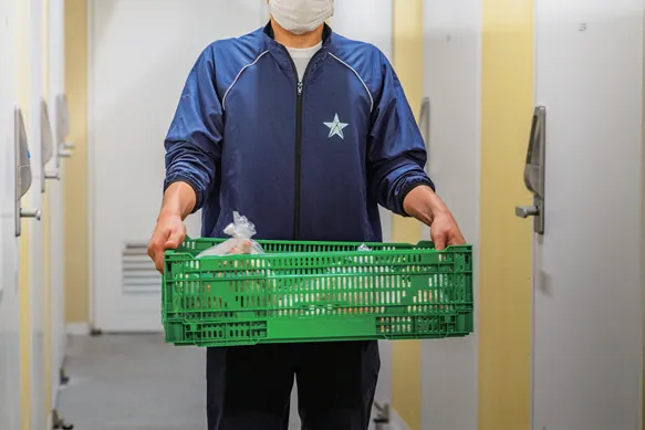 カゴを運ぶスタッフ
